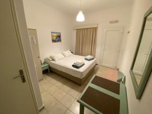a bedroom with a bed and a table and a chair at Annoula Studios and Apartments in Kardamaina