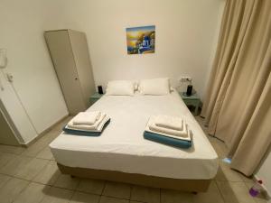 a bedroom with a bed with towels on it at Annoula Studios and Apartments in Kardamaina