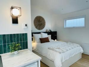 a bedroom with a bed with a green accent wall at Pavillon Neuf Baie de Tadoussac Clim Parking - 1 chambre in Tadoussac