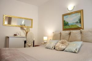 a bedroom with a white bed with a mirror at Avalena Rooms in Zadar