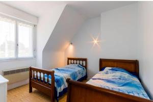 a bedroom with two beds and a star on the wall at Maison familiale pour 8 - 850m de la plage in Le Pouliguen