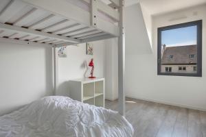 a white bedroom with a bed and a window at Maison 3 chambres avec beau jardin à Guérande in Guérande
