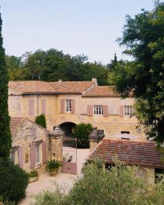 a large stone house with a gate and a driveway at Mas des Comtes de Provence in Tarascon