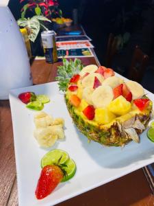 a fruit salad on a white plate with a pineapple at Eco Hotel Las Palmeras in Isla Grande