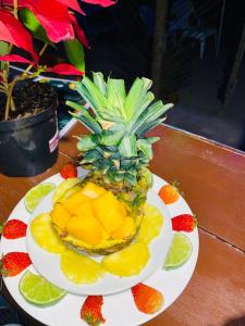 una piña en un plato con fruta en una mesa en Eco Hotel Las Palmeras en Isla Grande