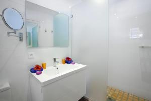 a white bathroom with a sink and a mirror at Villa Flamboyant, heated swimming pool, sublime view of Anse Marcel, 4 bedrooms in Anse Marcel 