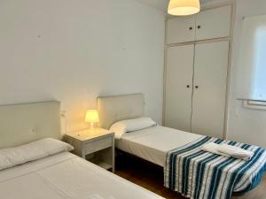a bedroom with two beds and a table with a lamp at Sa Posta in Cala en Forcat +8 photos