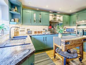 une cuisine avec des placards verts et une table en bois dans l'établissement 1 Bed in Ulverston 82447, à Gleaston