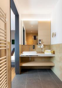 ein Badezimmer mit einer Badewanne und einem großen Spiegel in der Unterkunft Boutiquehotel zur Winzerstube - Adults Only in Hagnau