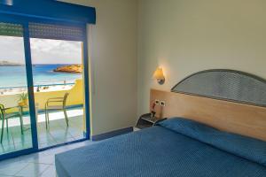 - une chambre avec un lit et une vue sur la plage dans l'établissement Hotel Baia Turchese, à Lampedusa