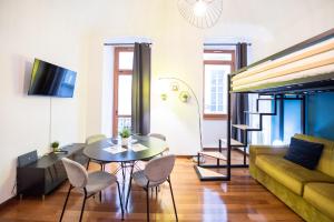 a living room with a couch and a table and chairs at Loft centro storico in Turin