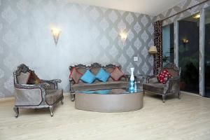 uma sala de estar com duas cadeiras e um sofá em Gem Near Lotus Temple em Nova Deli