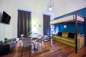 a living room with a bed and a table and chairs at Loft centro storico in Turin