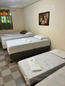 a group of three beds in a room at Pousada Villa Bella in Palmeiras +107 photos
