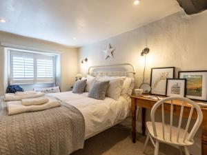 1 dormitorio con 1 cama con escritorio y silla en 2 Bed in Minchinhampton 77489 en Minchinhampton
