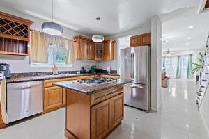 a kitchen with wooden cabinets and a stainless steel refrigerator at The Miller House in Nassau