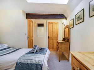 a bedroom with a bed and a wooden dresser at 3 Bed in Blanchland CN110 