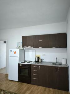 a kitchen with brown cabinets and a white refrigerator at Ristevski Apartment in Bitola