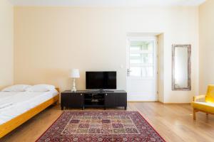 a bedroom with a bed and a flat screen tv at Victus Apartamenty, Apartament Garden in Sopot