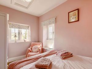 - une chambre avec un lit, une chaise et deux fenêtres dans l'établissement 2 Bed in Harrogate 75268, à Lindley