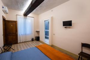 a bedroom with a bed and a tv on the wall at Locanda del Centrale in Cremona