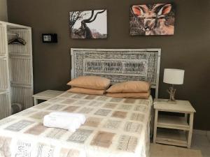 una camera da letto con un grande letto con due tavoli e una lampada di Chinaka Game Lodge a Vivo