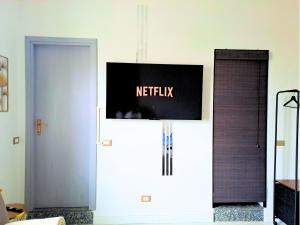 een televisie aan een muur in een kamer met een deur bij A due passi da Milano - Rho Fiera - Malpensa - Como in Saronno