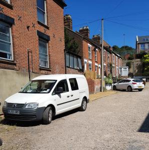 ein weißer Van vor einem Backsteingebäude geparkt in der Unterkunft Stay Norwich Apartments Trade Stay House in Norwich