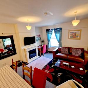 ein Wohnzimmer mit einem Sofa und einem Tisch in der Unterkunft Stay Norwich Apartments Trade Stay House in Norwich