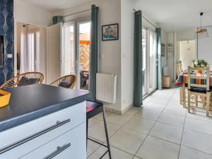 a kitchen and living room with a table and chairs at Maison Les Agapanthes in Les Sables-d'Olonne