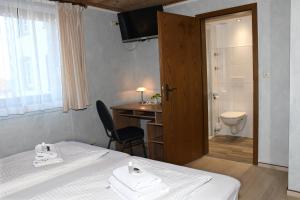 um quarto de hotel com uma cama e uma casa de banho em Gästehaus Zum Stehling em Monschau