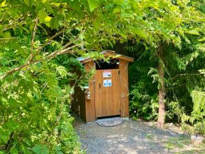 a wooden outhouse in the middle of a forest at So Damn Lucky Glamping in Ucluelet
