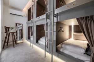 2 łóżka piętrowe w pokoju z lustrem w obiekcie Nidhra Boutique w mieście Bangkok