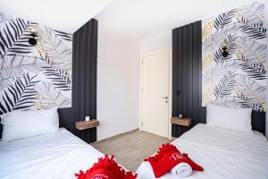 um quarto com 2 camas e almofadas vermelhas em GÜL RESİDENCE em Zeytinkoy