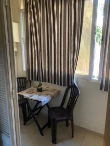 a table and two chairs in a room with a window at Duplex T3 Bien Situé in Annaba