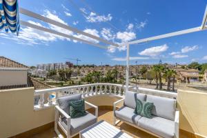 een balkon met twee stoelen en uitzicht op een stad bij AZUL by the Sea in Villamartin