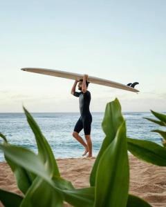 サフィにある5A private room in a shared house for surfersの浜辺のサーフボードを持つ男