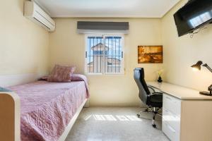 een slaapkamer met een bed, een bureau en een raam bij AZUL by the Sea in Villamartin +29 foto's