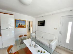 un soggiorno con divano bianco e tavolo in vetro di One bedroom apartement at Novigrad 400 m away from the beach with enclosed garden and wifi a Novigrad Istria