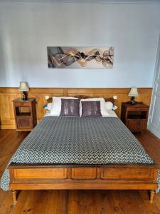 a bed in a bedroom with two night stands and two lamps at La Bagatelle in Pontorson