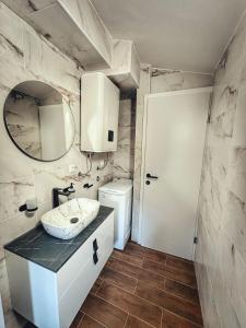 a bathroom with a sink and a mirror at Knežević Apartments in Crikvenica