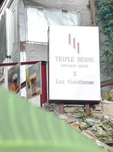 Un cartel que dice triple vigas. La corte de personalidad tiene casa de huéspedes. en Lux Guesthouse, en Islas Phi Phi