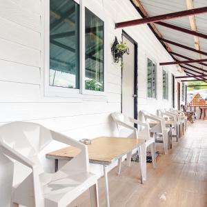 een eetkamer met witte stoelen en een houten tafel bij Lux Guesthouse in Phi Phi Don