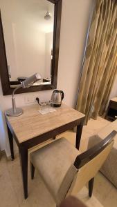 een tafel met een lamp en een stoel in een kamer bij Metropolis Tourist Home Paharganj in New Delhi