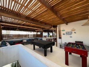 a patio with a pool table and ping pong tables at Vila Mucugê Pousada e Hostel in Arraial d'Ajuda