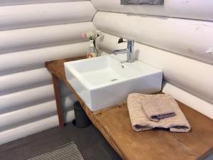a bathroom with a white sink and a wooden table at Private Mountain Log Cabin with amazing panoramic sunset views at small scale nature resort in Cabeceiras de Basto +104 photos