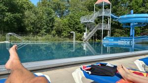 a man laying on a raft in front of a water park at Wetter_wille in Earnewâld