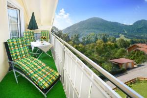 a balcony with two chairs and a table with a view at Am Badezentrum Ferienwohnungen in Ruhpolding
