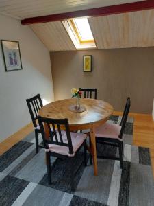 ein Holztisch mit Stühlen und einer Blumenvase darauf in der Unterkunft Haus Basilea in Wolfhalden 