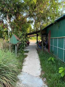 un sentier de randonnée à côté d'un bâtiment vert dans l'établissement Maloop Cafe Bungalow, à Koh Rong